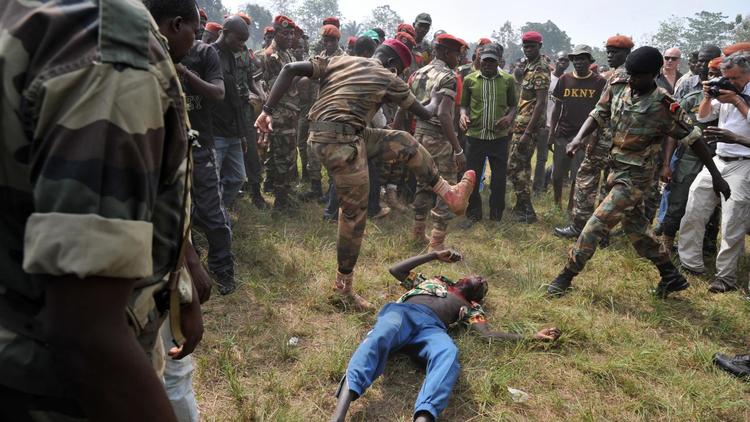Des soldats lynchent un ex-rebelle présumé à la fin d'une cérémonie officielle, à Bangui le 5 février 2014 [Issouf Sanogo / AFP]