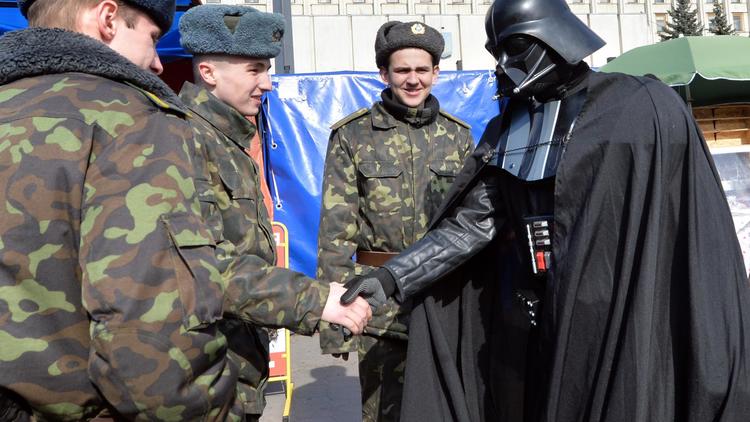 Sa candidature à la présidentielle rejetée, Dark Vador du parti UIP salue des soldats ukrainiens le 3 avril 2014 à Kiev  [Sergei Supinsky / AFP]