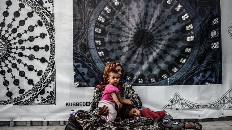 Une réfugiée syrienne mendie avec son enfant dans une rue d'Istanbul, le 16 juillet 2014 [Bulent Kilic / AFP]