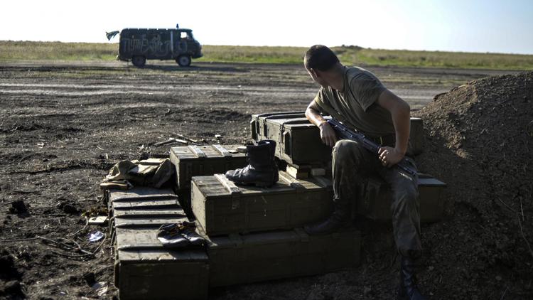 Un soldat ukrainien sur le bord de la route près de Lougansk à l'Est de l'Ukraine le 20 août 2014 [Aleksey Chernyshev / AFP]