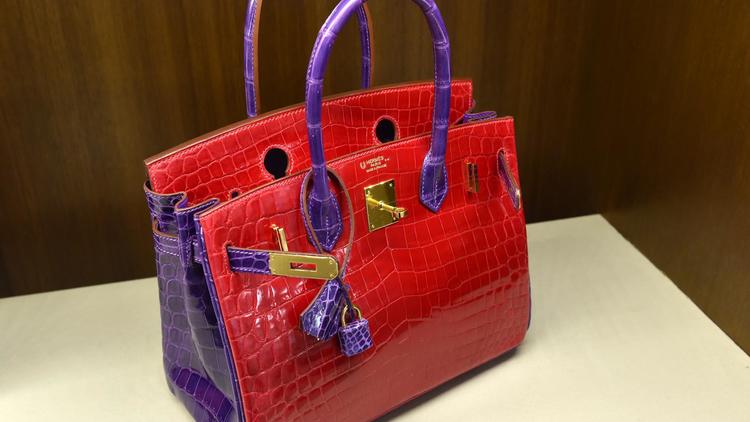 Un "Birkin" Hermès en crocodile rouge et violet, une pièce unique issue d'une commande spéciale qui fait partie des sacs vendus aux enchères chez Heritage, est présenté le 7 avril 2014 à New York [Stan Honda / AFP/Archives]