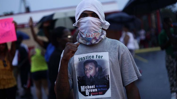 Un homme manifeste après la mort d'un jeune Noir tué par un policier, le 15 août 2014 à Ferguson dans le Missouri [Joshua Lott / AFP]