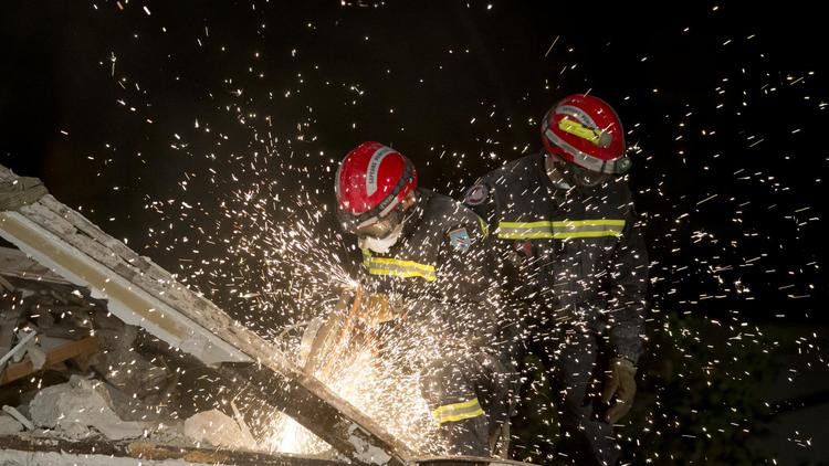 Des pompiers le 1er septembre 2014 au milieu des décombres de l'immeuble qui s'est effondré à Rosny-sous-Bois [Kenzo Tribouillard / AFP]