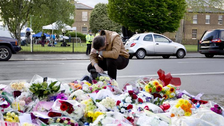 Un homme se recueille le 23 mai 2013 à l'endroit où un soldat a été tué par deux suspects, dans le quartier de Woolwich, à Londres [Justin Tallis / AFP]
