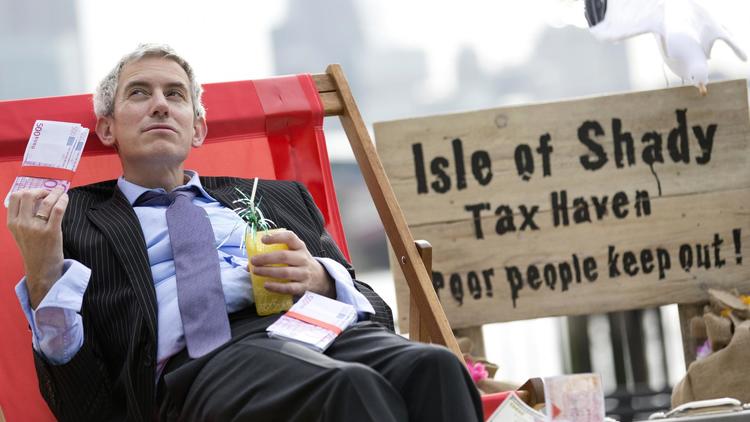Un manifestant incarnant un banquier s'évente avec un liasse de faux billets, le 14 juin 2013 à Londres [Justin Tallis / AFP]