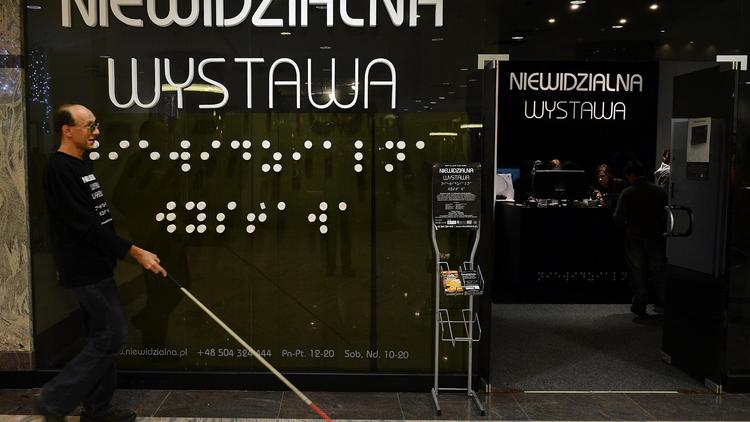 Un aveugle passe devant l'entrée de "l'exposition invisible", le 18 décembre 2012 à Varsovie [Janek Skarzynski / AFP]
