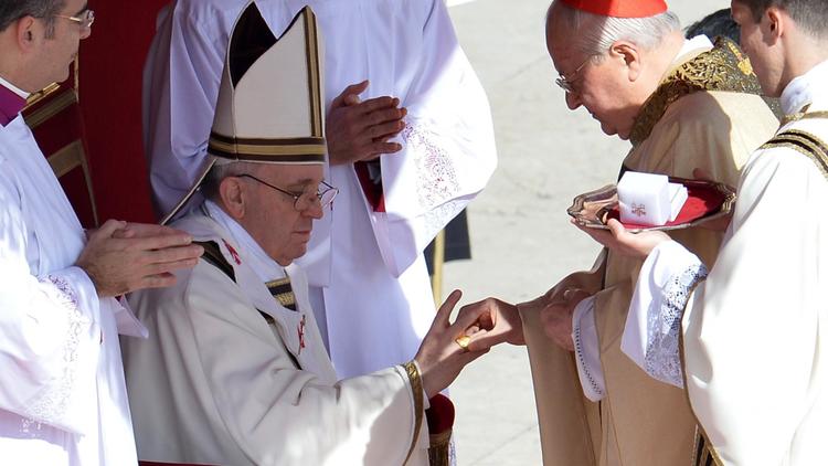 Le cardinal italien Angelo Sodana enfile l'anneau du pêcheur au doigt du pape, le 19 mars 2013 lors de la messe inaugurale au Vatican