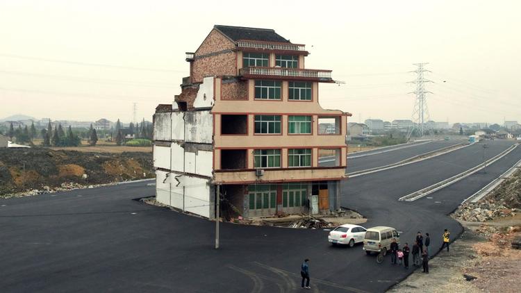 L'immeuble dans lequel vit un couple d'irréductibles Chinois se retrouve isolé au milieu d'une route en construction, le 22 novembre 2012 [ / AFP]