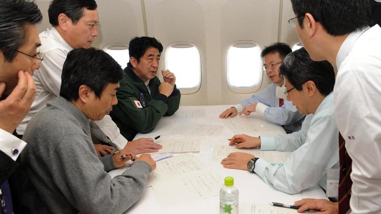 Le premier ministre japonais Shinzo Abe (4è gauche) participe le 18 janvier 2013 à une réunion de crise à bord de l'avion utilisé lors de sa tournée en Asie [Jiji Press / Jiji Press/AFP]