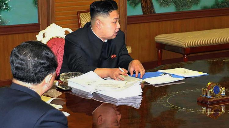 Photo non datée fournie par l'agence nord-coréenne KCNA le 27 janvier 2013, montrant le numéro 1 nord-coréen Kim Jong-Un présidant une réunion en possession d'un smartphone