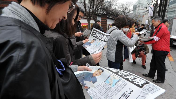 Des personnes lisent les journaux pour obtenir des informations sur le 3e essai nucléaire nord-coréen, le 12 février 2013 à Tokyo [Kazuhiro Nogi / AFP]