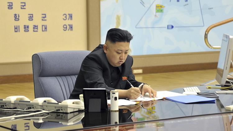 Photo de l'agence officielle nord-coréenne montrant Kim Jong-Un en train de signer des documents dans un lieu non identifié, le 29 mars 2013 [ / KCNA via Kns/AFP]
