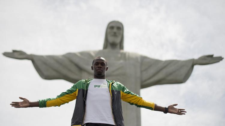 Le sprinteur jamaïcain Usain Bolt pose devant  le Christ rédempteur au Corcovado à Rio, le 23 octobre 2012. [Christophe Simon / AFP]