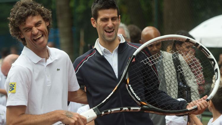 Novak Djokovic (c) et Gustavo Kuerten, lors de l'inauguration d'un terrain de tennis dans une favela de Rio, le 16 novembre 2012 [Christophe Simon / AFP]