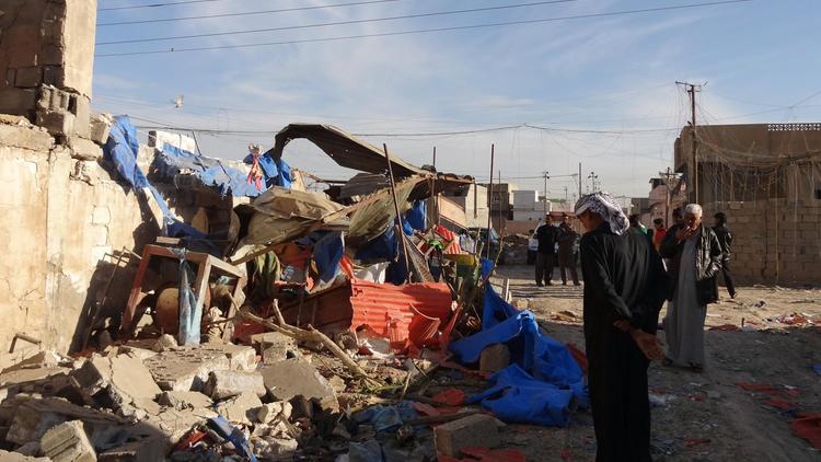 Des civils irakiens constatent les dégâts causés par une voiture piégée à Kirkouk, le 20 mars 2013 [Marwan Ibrahim / AFP]