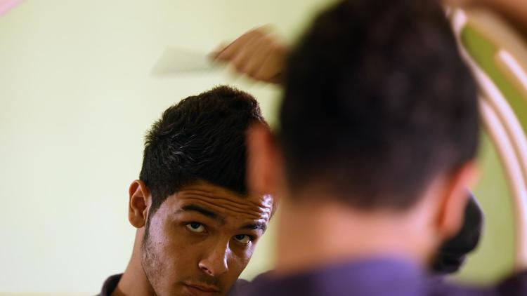 Un jeune homme se coiffe à Gaza le 8 avril 2013 [Mohammed Abed / AFP]
