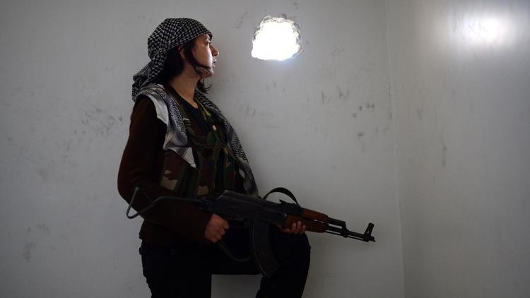 Une jeune femme kurde observe les positions des forces syriennes, le 14 avril 2013 à Alep [Dimitar Dilkoff / AFP]