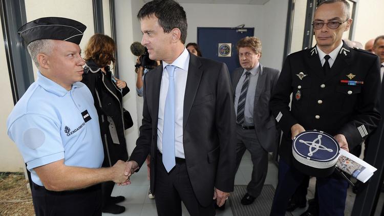Le ministre de l'Intérieur Manuel Valls serre la main d'un gendarme, le 17 septembre 2012 à Vauvert, dans le sud de la France [Pascal Guyot / AFP]
