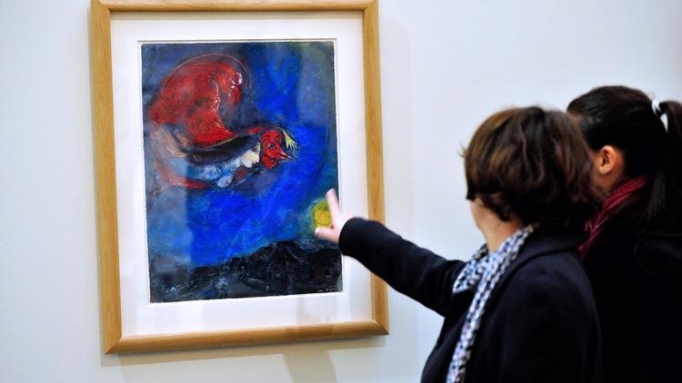 Des visiteurs regardent le tableau 'Le coq rouge" à l'exposition sur Chagall à la Piscine de Roubaix [Philippe Huguen / AFP]