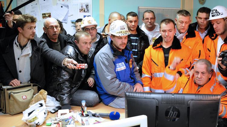 Des salariés d'ArcelorMittal écoutent la déclaration du Premier ministre Jean-Marc Ayrault à la télévision, le 30 novembre 2012 à Florange [Jean-Christophe Verhaegen / AFP]