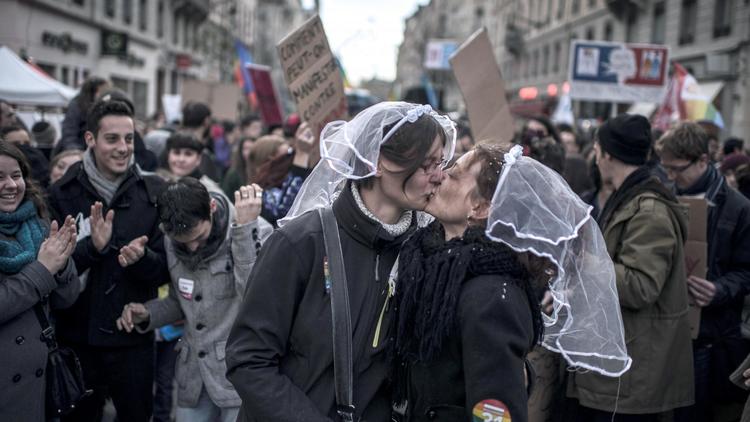 Deux femmes avec un voile de mariée s'embrasse lors d'une manifestation en faveur du mariage pour les couples homosexuels, le 15 décembre 2012 à Lyon [Jeff Pachoud / AFP]