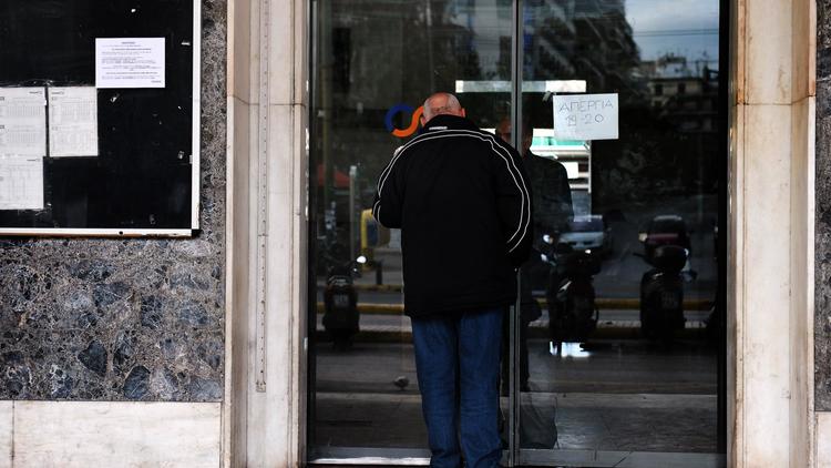 Un homme butte contre la porte fermée de la gare d'Athènes lors de la grève de la fonction publique, le 19 décembre 2012 [Louisa Gouliamaki / AFP]