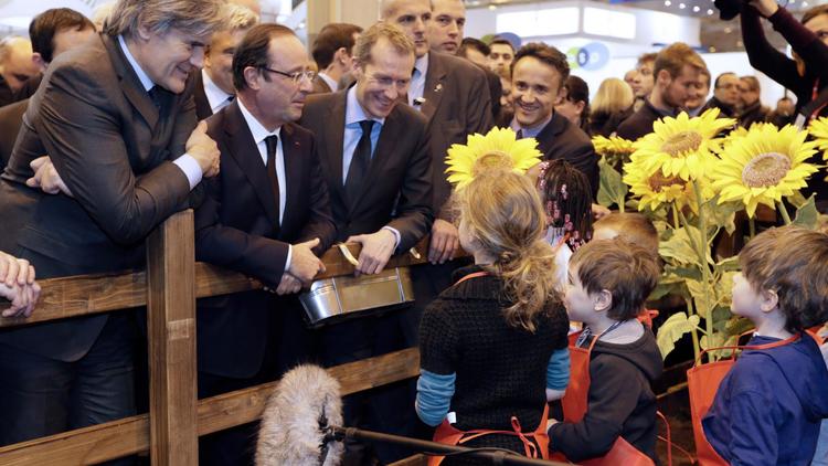 Des enfants présentent des tournesols au président François Hollande (c), le 23 février 2013 au salon de l'agriculture à Paris [Kenzo Tribouillard / AFP]