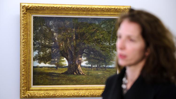 Une femme passe devant une toile de Courbet, le "Chêne de Flagey", le 9 mars à Ornans, dans le Doubs [Sebastien Bozon / AFP]