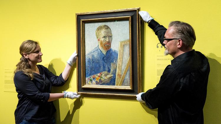 Des employés du musée Van Gogh d'Amsterdam accrochent le tableau "Autoportrait de l'artiste" datant de 1888, le 1er mai 2013 à Amsterdam [Koen van Weel / ANP/AFP]