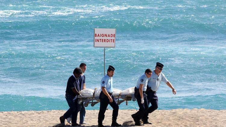 Des gendarmes transportent le corps du Français tué par un requin, à la Réunion le 8 mai 2013 [Richard Bouhet / AFP]