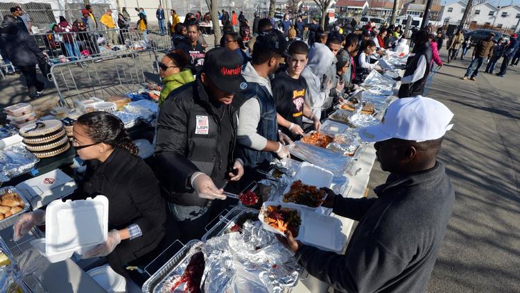 Des volontaires distribuent des repas pour la Thanksgiving aux New-Yorkais victimes de l'ouragan Sandy, le 22 novembre 2012 dans le quartier du Queens [Stan Honda / AFP]