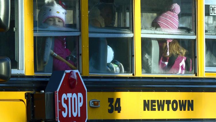 Des élèves de l'école Sandy Hook à Newtown dans le Connectictut prennent le bus scolaire pour aller dans leur nouvel établissement, le 3 janvier 2013 [Timothy A. Clary / AFP]