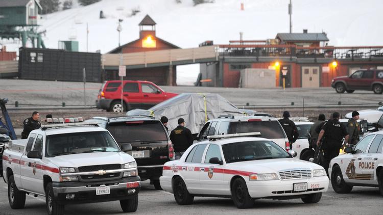 Des policiers autour du véhicule calciné (sous bâche) de Christopher Jordan Dorner, un ex-policier recherché pour meurtres, le 7 février 2013 à Big Bear, en Californie