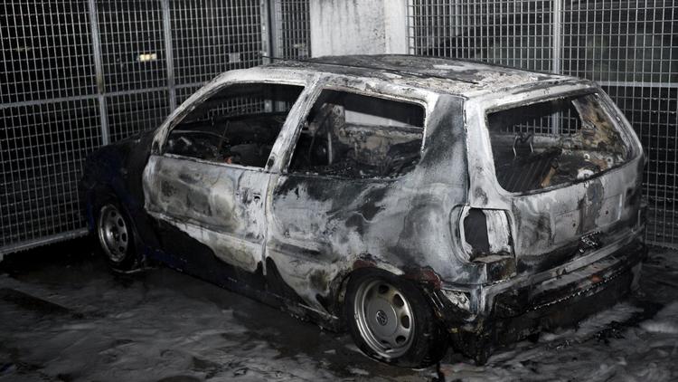 Une voiture incendiée le 24 mai 2013 dans la banlieue de Stockholm [Jonathan Nackstrand / AFP]