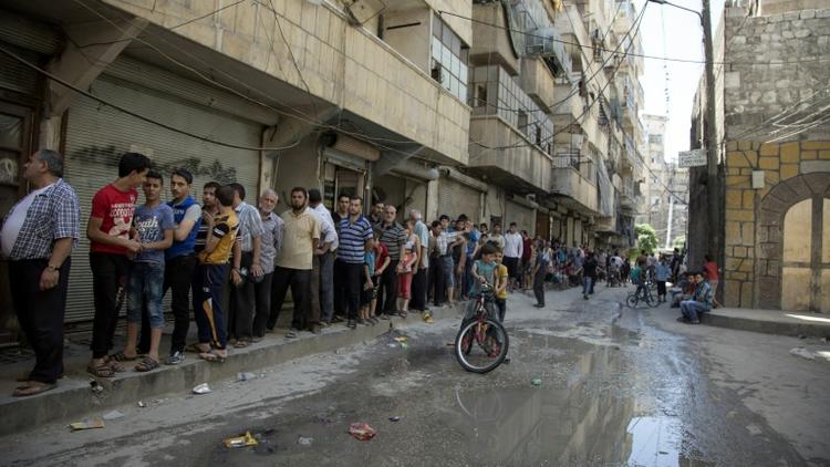 Des Syriens font la queue pour acheter du pain à Alep le 12 juillet 2016 [KARAM AL-MASRI / AFP/Archives]