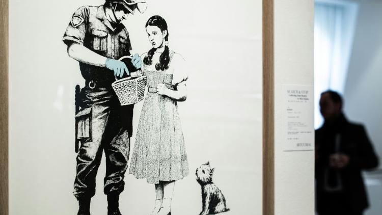 Une oeuvre du street artist Banksy exposée le 18 octobre 2018 à Paris avant une vente aux enchères par la maison Artcurial, le 24 octobre [Philippe LOPEZ / AFP]