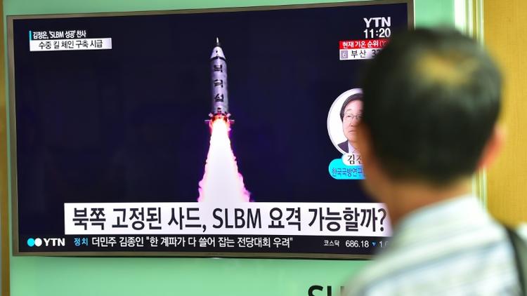 Photo du 25 août 2016 prise à la gare de Séoul, montrant un homme qui regarde des informations à la télévision faisant état d'un essai de missile balistique nord-coréen à partir d'un sous-marin. [JUNG YEON-JE / AFP/Archives]