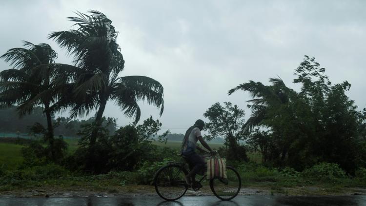 Un homme à vélo sous la pluie, avant l'arrivée du cyclone Amphan, le 20 mai 2020 à Midhapore, en Inde [Dibyangshu SARKAR / AFP]