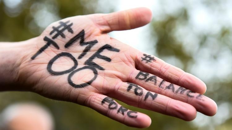 Une main arborant les expressions "#Me too" et #Balancetonporc pendant un rassemblement contre les violences sexuelles et de genre organisées par l'association Les Effronté-e-s, Place de la République à Paris le 29 octobre 2017. [BERTRAND GUAY / AFP]