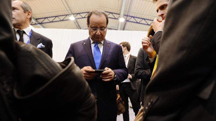 François Hollande utilise son smartphone le 29 novembre 2013 à Vilnius [Alain Jocard / AFP/Archives]
