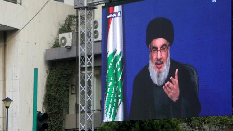 Photo prise le 25 octobre 2019 à Beyrouth montrant le chef du Hezbollah, Hassan Nasrallah, s'exprimant sur un écran géant au 9e jour d'une mobilisation inédite contre la classe politique qui paralyse le Liban. [Patrick BAZ / AFP]
