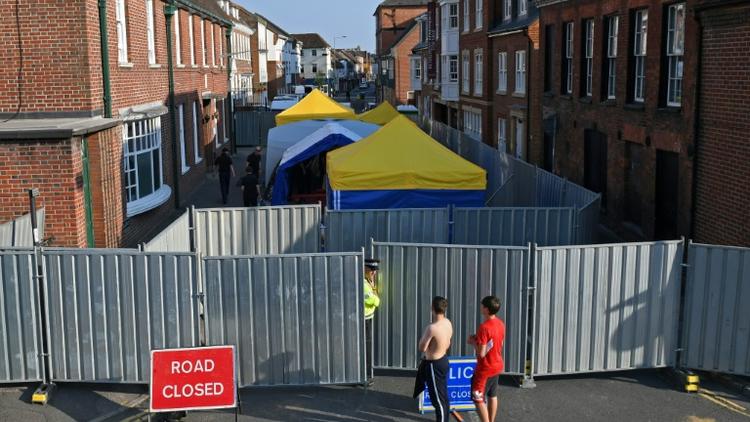 Un policier monte la garde le 5 juillet 2018 devant une barrière interdisant l'accès à une rue d'Amesbury, dans le sud de l'Angleterre, où un couple exposé au Novitchok est tombé malade [Chris J Ratcliffe / AFP]