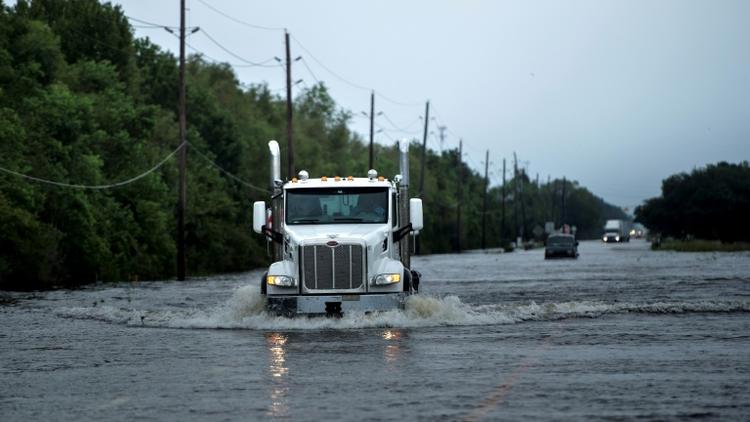 Des camions se fraient un passage vers l'usine chimique d'Arkema à Crosby près de Houston (Texas), le 30 août 2017 [Brendan Smialowski / AFP]
