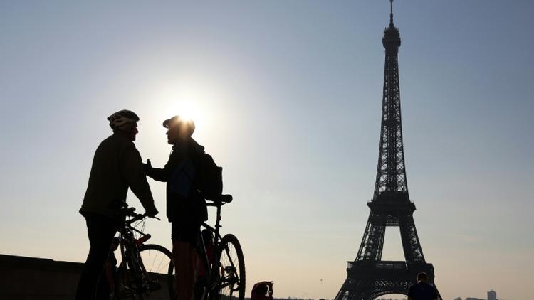 Deux cyclistes discutent devant la tour Eiffel avant de participer à la "journée sans voiture" organisée par la mairie de Paris, le 27 septembre 2015 [LUDOVIC MARIN / AFP/Archives]