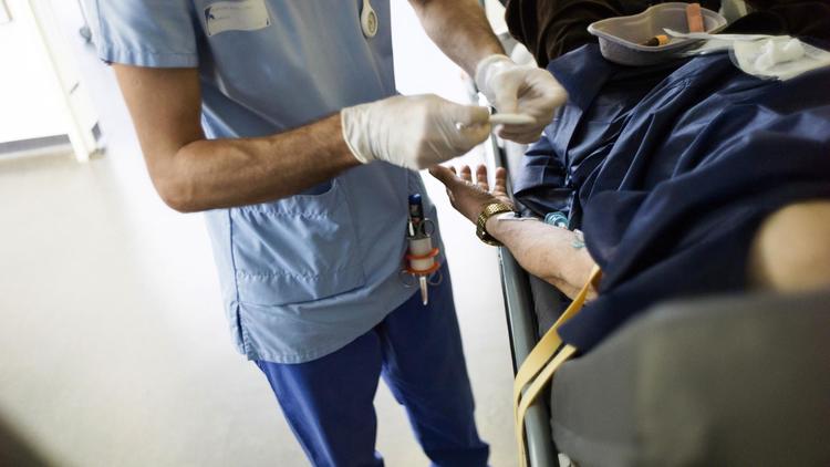 Un médecin soigne un patient à Paris [Fred Dufour / AFP/Archives]