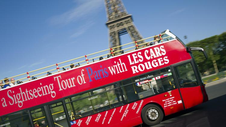 Un bus de la compagnie des Cars rouges passe devant la Tour Effeil à Paris, le 3 août 2012 [Lionel Bonaventure / AFP/Archives]