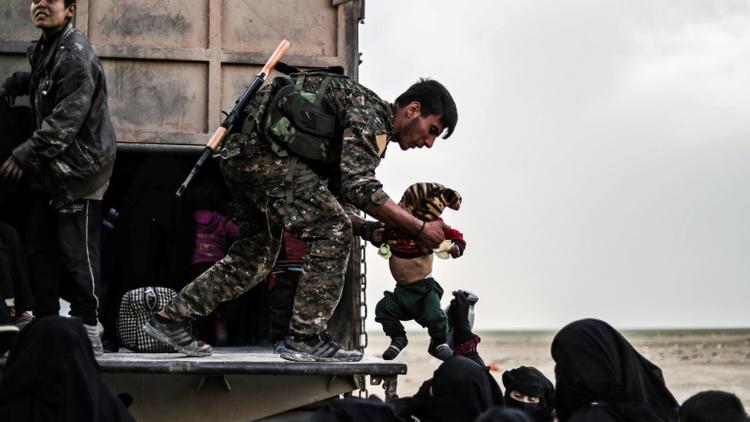 Un combattant des Forces démocratiques syriennes (FDS) durant l'évacuation de femmes et enfants du dernier réduit du groupe Etat islamique (EI), le 26 février 2019 dans la province de Deir Ezzor [Delil SOULEIMAN / AFP]