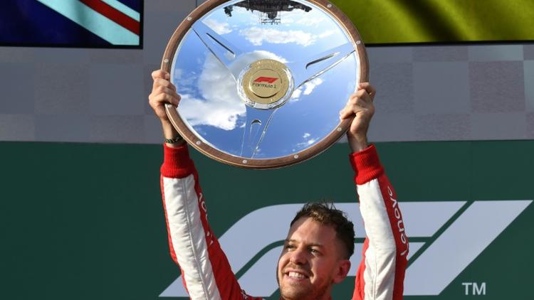 L'Allemand Sebastian Vettel (Ferrari) soulève le trophée après sa victoire au GP d'Australie ouvrant la saison de F1, le 25 mars 2018 à Melbourne  [SAEED KHAN / AFP]
