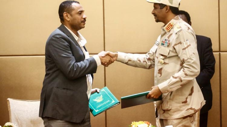 Le numéro deux  du Conseil militaire au pouvoir au Soudan Mohammed Hamdane Daglo (droite) et le leader de la contestation Ahmed Rabie se serrent la main après avoir signé la déclaration constitutionnelle actant la création d'un pouvoir civil, le 4 août 2019 à Khartoum [ASHRAF SHAZLY / AFP]