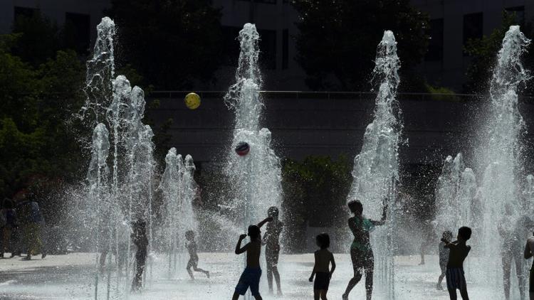 Des enfants jouent avec des jets d'eau au parc André Citroen le 26 juillet 2018 à Paris [ALAIN JOCARD / AFP/Archives]